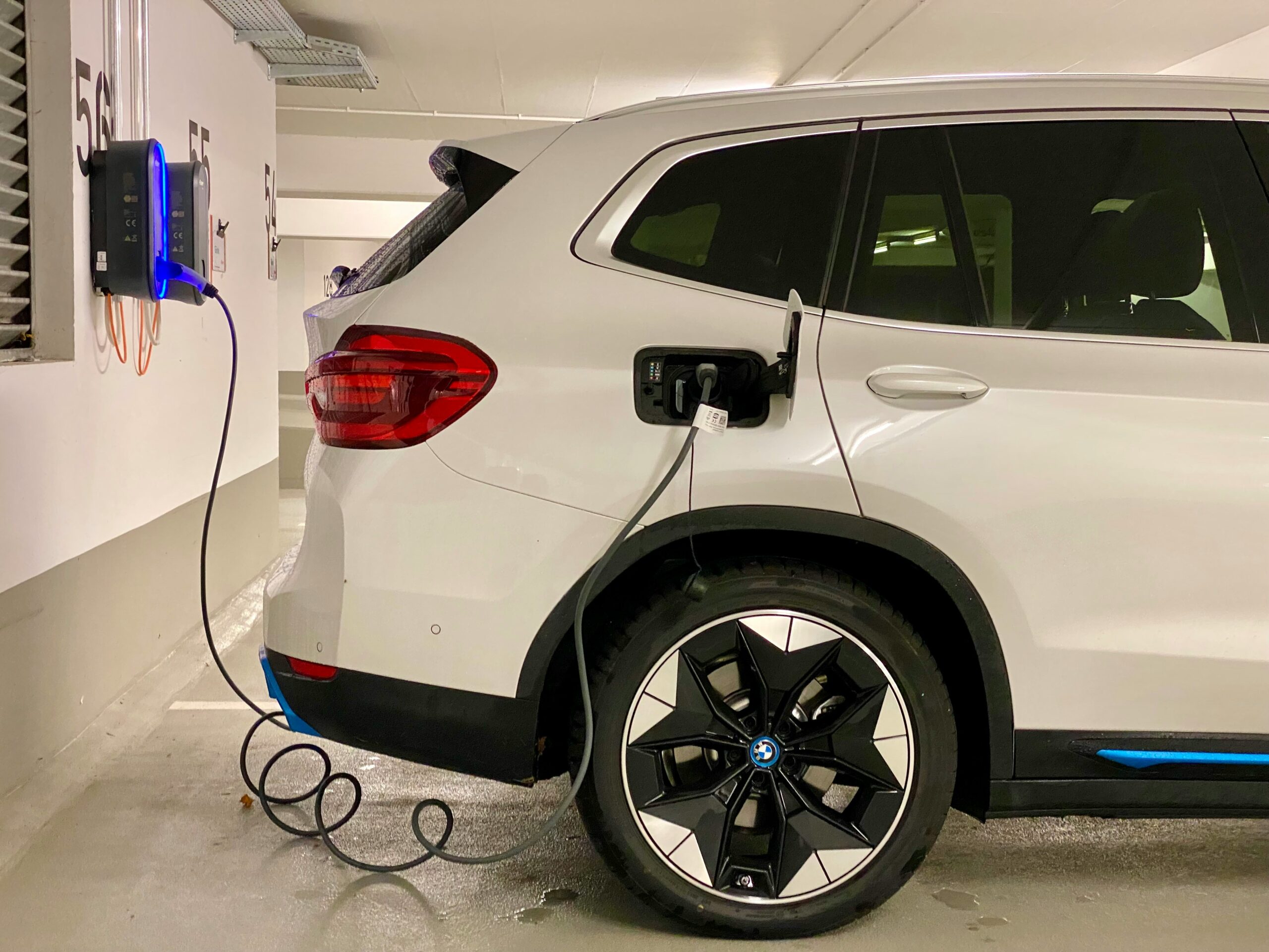 Coche eléctrico cargando en una plaza de garaje